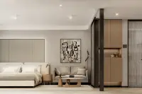 Studio Condo for Sale at Level Pratumnak bedroom with abstract art, sofa and wood-paneled kitchenette entry
