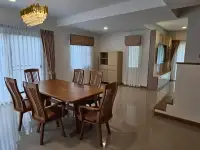 4 Bedroom House for Rent at Life in the Garden Rongpo - Motorway open-plan dining area with wooden table and crystal chandelier