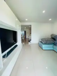 4 Bedroom House for Rent at Life in the Garden Rongpo - Motorway living room with wall-mounted TV and blue sofa