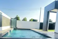 4 Bedroom House for Sale in Pong, rectangular outdoor swimming pool with dark tiles and a shower feature.