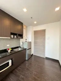 1 Bedroom Condo for Sale at Pattaya Posh kitchenette with dark cabinetry and entrance door