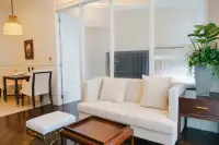 1 Bedroom Condo for Rent at Grand Florida Beachfront Condo Resort Pattaya living room with white sofa glass partition and dark wood dining table