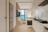 1 Bedroom Condo for Sale at Lucean Bay Jomtien Pattaya galley kitchen with marble island, oven, and sea view through floor-to-ceiling windows