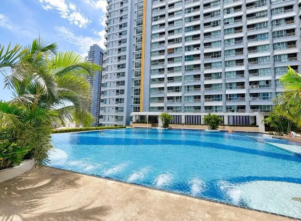 1 Bedroom Condo for Rent at Lumpini Park Beach Jomtien outdoor pool with palm trees and high-rise tower view