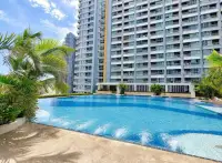 1 Bedroom Condo for Rent at Lumpini Park Beach Jomtien outdoor pool with palm trees and high-rise tower view