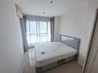 1 Bedroom Condo for Sale at Lumpini Park Beach Jomtien bedroom with sea-view window and gray tufted bed