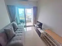 1 Bedroom Condo for Sale at Lumpini Park Beach Jomtien living room with sofa, TV and balcony sea view