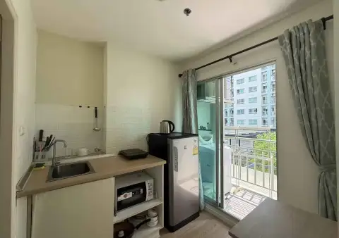 1 Bedroom Condo for Sale at Lumpini Seaview Jomtien kitchenette with sink, fridge, microwave, and balcony view