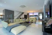 8 Bedroom House for Sale in Pratumnak Hill open-plan living room with cream sectional sofa and floating staircase