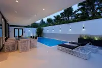 8 Bedroom House for Sale in Pratumnak Hill poolside patio with lounge chairs and outdoor dining at dusk
