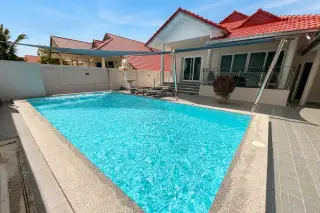 Royal Prestige spacious outdoor private pool with shade sail, lounge chairs, and glass balustrade terrace