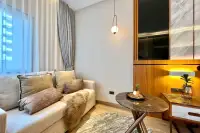 Studio Condo for Sale at Wyndham Jomtien Pattaya: cozy living area with a sofa, coffee table, and soft lighting.