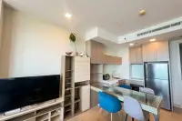 1 Bedroom Condo for Sale at Cetus Beachfront kitchen and dining area with wood cabinets, stainless steel fridge and flat-screen TV