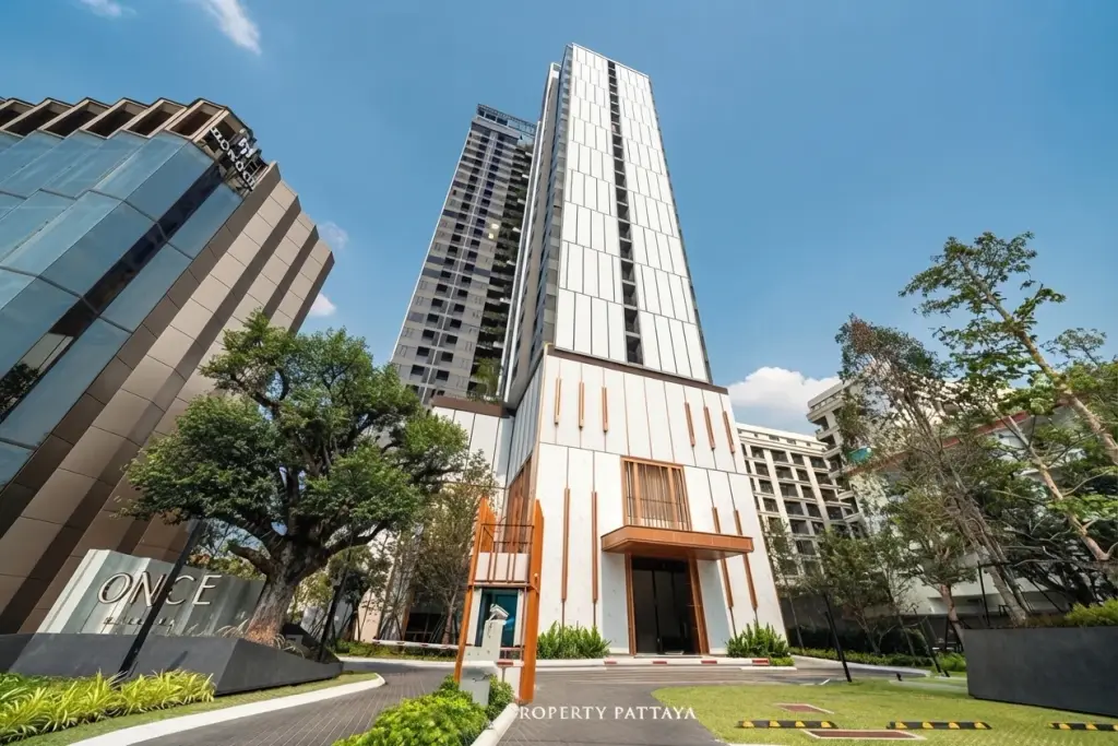 Once Pattaya modern condo building exterior with contemporary architecture and lush green landscaping.