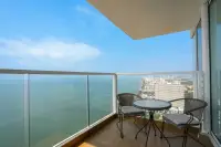 3 Bedroom Condo for Sale at Cetus Beachfront glass-railed balcony with rattan seating set overlooking Pattaya coastline and ocean