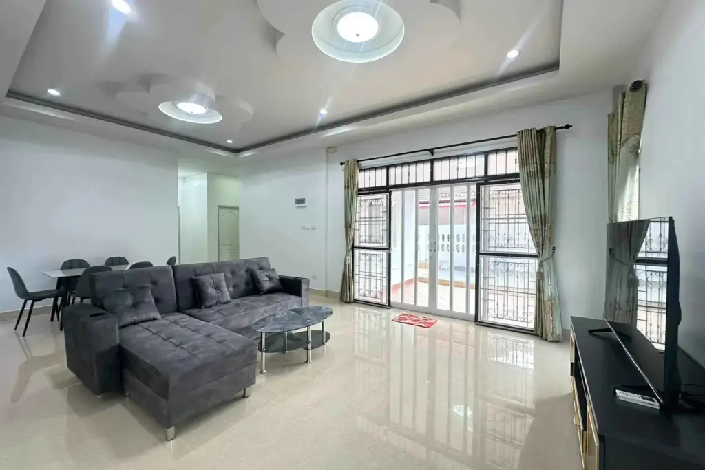 3 Bedroom House for Rent in Mabprachan living room with gray sectional sofa and glass doors to pool patio