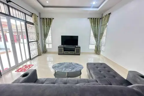 3 Bedroom House for Rent in Mabprachan lounge area with TV stand and sliding glass doors to outdoor terrace