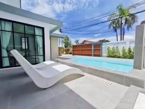 3 Bedroom House for Sale in Mabprachan poolside patio with white lounge chair and palm trees