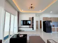 3 Bedroom House for Sale in Mabprachan open-plan living room with TV unit and kitchen area