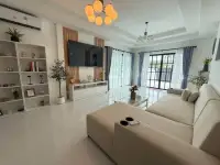 3 Bedroom House for Sale in Mabprachan bright living room with sofa, TV, and large windows