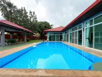 4 Bedroom House for Rent in Mabprachan poolside view with glass-walled living areas and covered patio