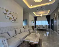 4 Bedroom House for Rent in Mabprachan featuring an elegant living room with tufted sofa and dining area