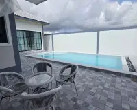 4 Bedroom House for Rent in Mabprachan showing rectangular pool with patio furniture and outdoor seating