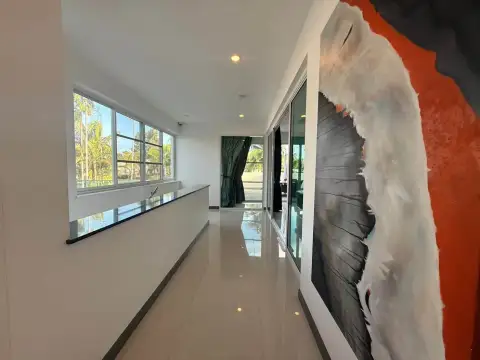5 Bedroom House for Rent in Mabprachan upstairs hallway with large windows, artwork and tiled flooring