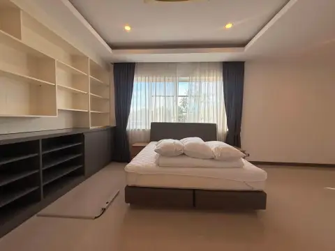 5 Bedroom House for Rent in Mabprachan spacious bedroom with built-in shelving and sheer curtained window