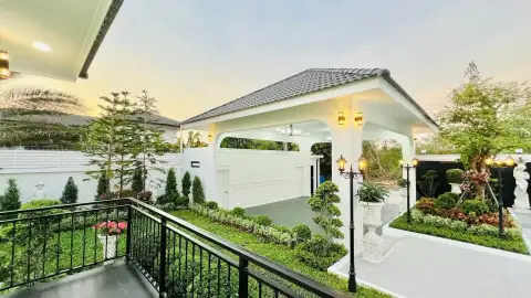 5 Bedroom House for Sale in Mabprachan covered carport and landscaped garden with statues at dusk