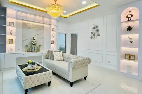 5 Bedroom House for Sale in Mabprachan elegant living room with tufted sofa, chandelier, and display shelving
