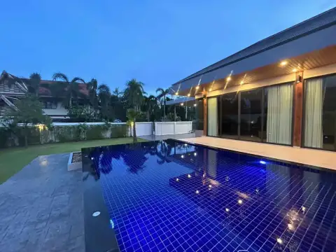 5 Bedroom House for Rent in Mabprachan illuminated infinity-edge pool at dusk with blue tile design