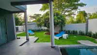 6 Bedroom House for Rent in Mabprachan backyard garden with blue sun loungers and covered patio