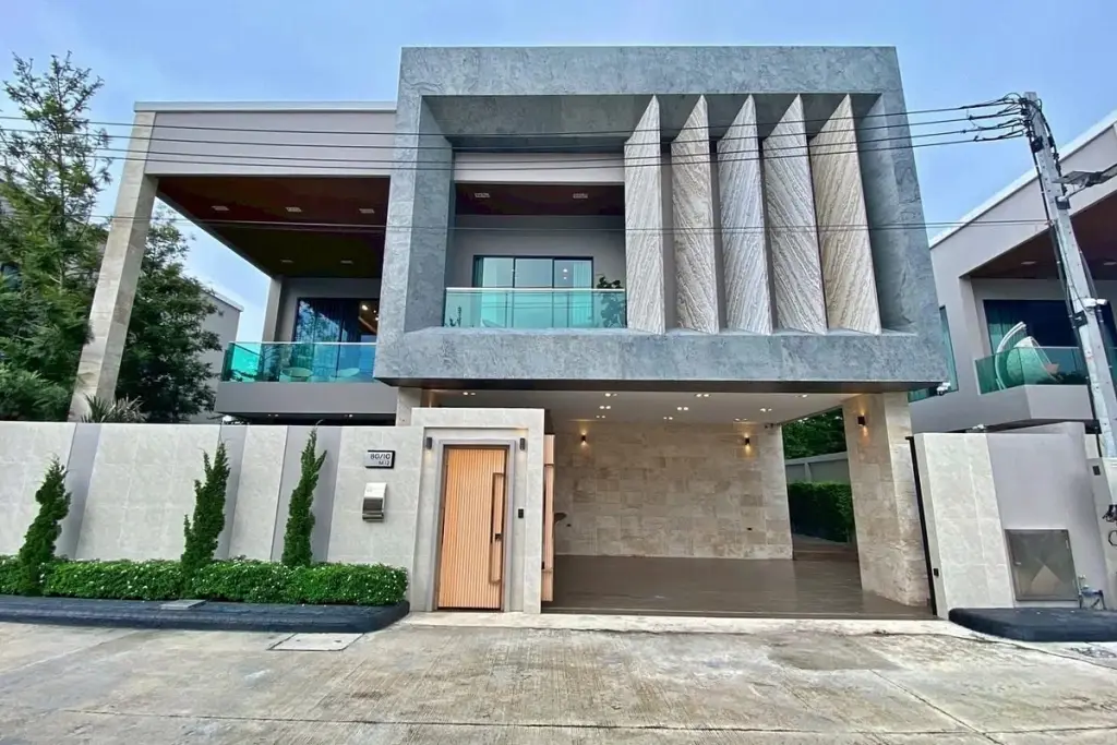 4 Bedroom House for Sale & Rent at Madcha Nirvana modern two-story facade with stone cladding and covered carport
