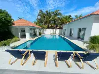 7 Bedroom House for Sale at Majestic Residence Pratumnak infinity-style pool with navy lounge chairs and tropical landscaping