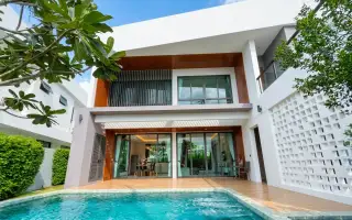 The S concepts modern house exterior with a swimming pool, wooden deck, and large glass doors on the ground floor.