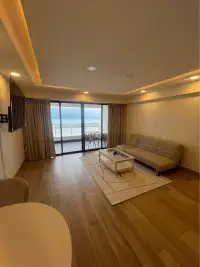 1 Bedroom Condo for Sale at Metro Jomtien Condotel living room with sea view balcony and wood flooring