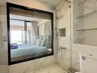 1 Bedroom Condo for Sale at Metro Jomtien Condotel marble bathroom with glass shower and bedroom view window