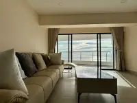 1 Bedroom Condo for Sale at Metro Jomtien Condotel living room with beige sofa and sea view balcony