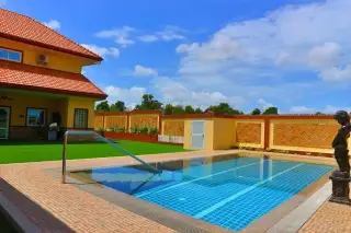 Miami Villas outdoor pool with stainless steel handrail green garden and yellow villa with red tile roof