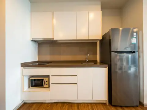 1 Bedroom Condo for Sale at Baan Plai Haad kitchenette with stainless steel fridge and white cabinets