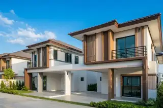 Pattalet 2 modern two-story houses with brown and white exteriors, balconies, and covered carports under a sunny sky.