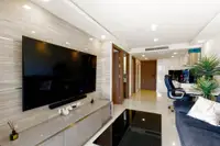 2 Bedroom Condo for Sale at Grand Avenue Residence: Living room with large wall-mounted TV and modern furniture.