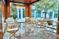 10 Bedroom House for Sale in Na Chom Thian: Indoor cafe area with wooden director chairs, marble floor, and large windows.