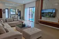 4 Bedroom House for Sale in Nong Prue, spacious living room with L-shaped sofa and view of the pool.