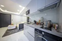 1 Bedroom Condo for Sale at Grand Solaire Noble compact kitchen with white cabinets, grey countertop, and washing machine