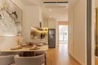 1 Bedroom Condo for Sale at Seaspire Jomtien dining and kitchen area with marble countertop, stainless fridge, and balcony view beyond