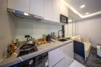1 Bedroom Condo for Sale at Grand Solaire Noble compact kitchen with white gloss cabinets, induction hob, and glass splashback