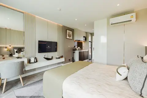 Studio Condo for Sale at The Coral Pattaya: Bedroom with full bed, side table, and view into the hallway.