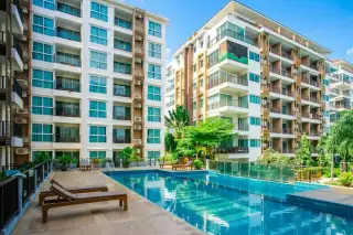 Diamond Suites Resort Condominium outdoor swimming pool with lounge chairs and two modern condo buildings.